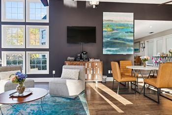 A living room with a couch and chairs and a table and a television